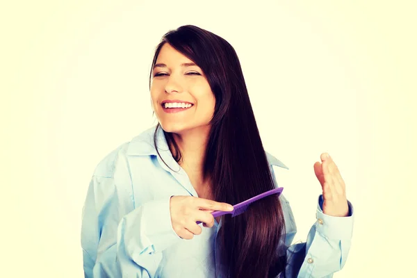 Mulher da manhã em camisa grande pentear o cabelo . — Fotografia de Stock