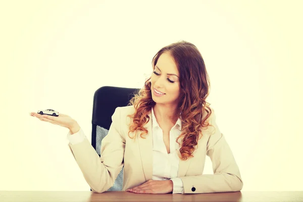 Business woman holding a toy car. — Stock Photo, Image