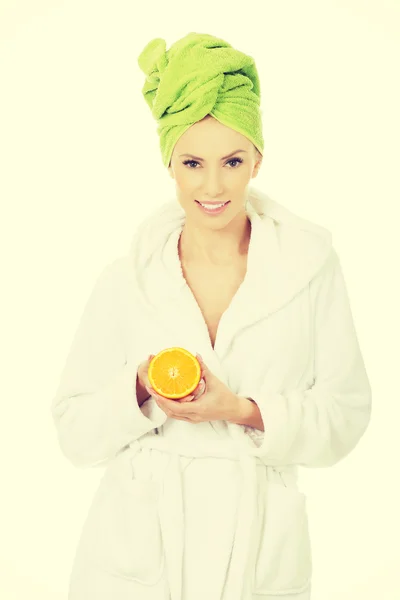 Wellness-Frau im Bademantel mit Orange. — Stockfoto