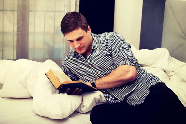 Onun yatakta kitap okurken erkek. — Stok fotoğraf