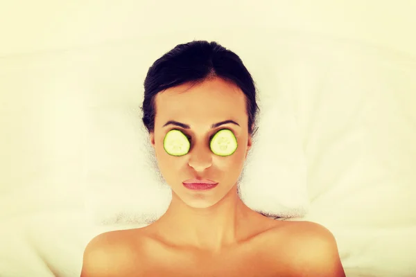 Mujer disfrutando del spa, teniendo pepino en los ojos — Foto de Stock