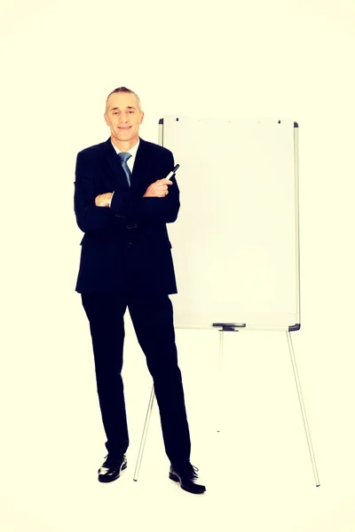 Male executive standing near flip chart — Stock Photo, Image