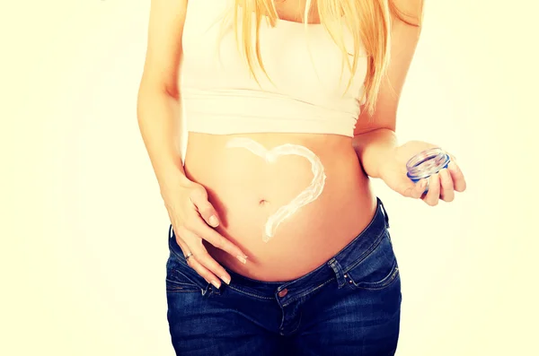 Pregnant woman applying cream on her belly — Stock Photo, Image