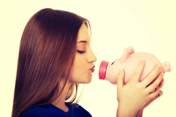 Teenage woman kissing piggybank. — Stock Photo, Image