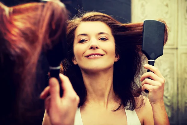 Brünette Frau streicht sich die Haare. — Stockfoto