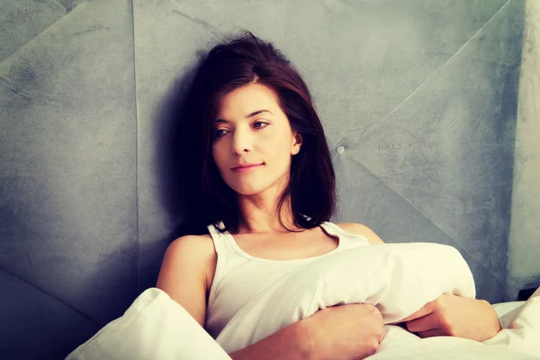 Mujer acostada en su cama en casa . — Foto de Stock