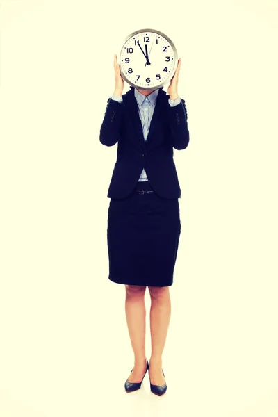 Business woman hiding behind big clock. Stock Picture