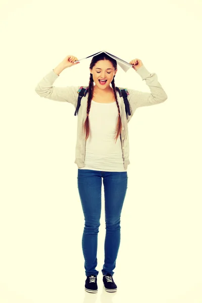 Adolescente chica con libro sobre su cabeza . — Foto de Stock