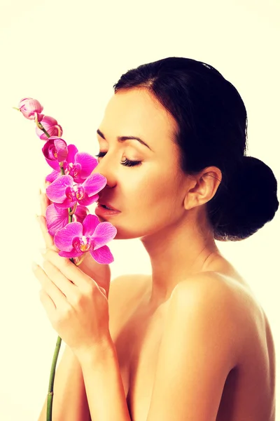 Topless vrouw met paars orchid branch — Stockfoto