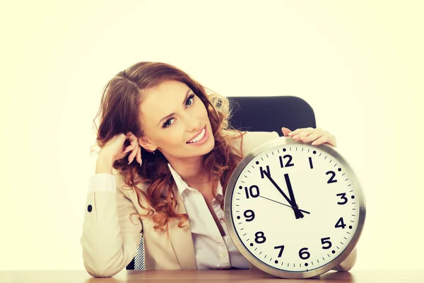 Femme d'affaires avec horloge par un bureau . — Photo