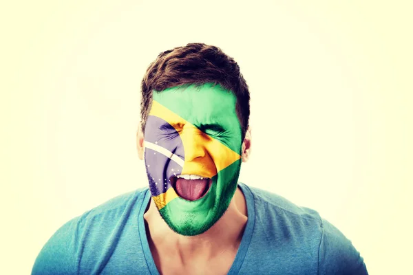 Mężczyzna z flaga Brazylii na twarzy krzyczy. — Zdjęcie stockowe