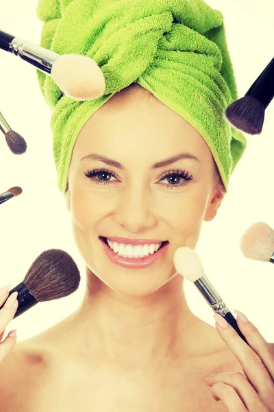 Young woman has brushes around face. — Stock Photo, Image