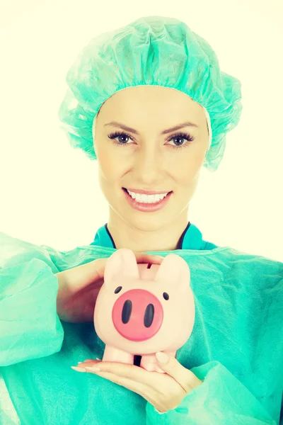 Médico feminino com banco piggy rosa . — Fotografia de Stock