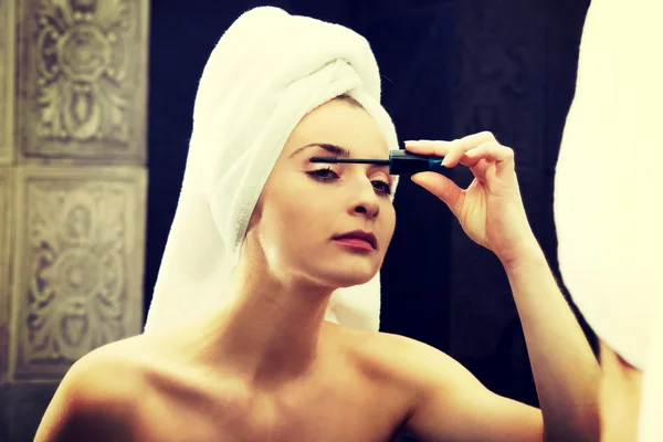 Mujer hace maquillaje de día ligero en el baño . —  Fotos de Stock