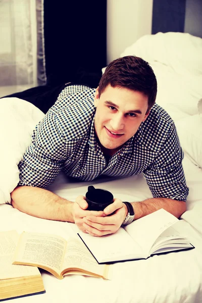 Szczęśliwy człowiek z książką w jego łóżku. — Zdjęcie stockowe