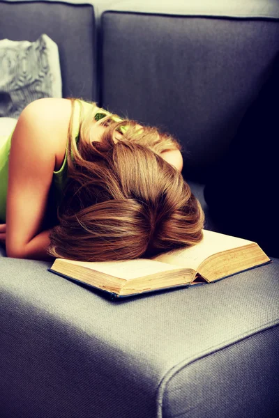 Tired woman with her head on book. — Stock Photo, Image