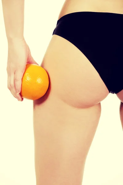 Fesses féminines et orange à la main . — Photo