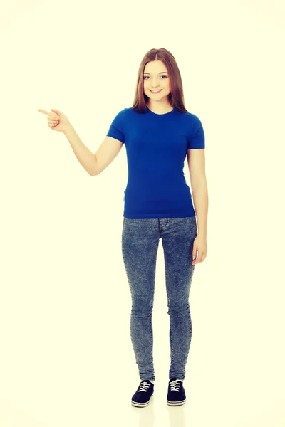 Leende ung kvinna som pekar åt sidan. — Stockfoto