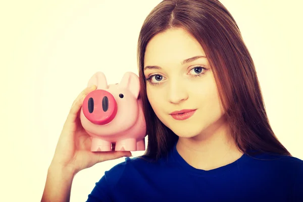 Tonåriga kvinna anläggning piggybank. — Stockfoto