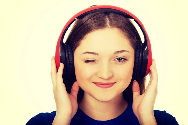 Woman with headphones blinks eye. — Stock Photo, Image