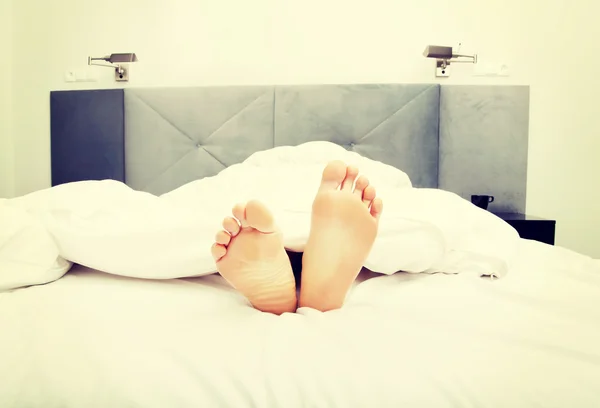 Desnudo womans pies en dormitorio . — Foto de Stock