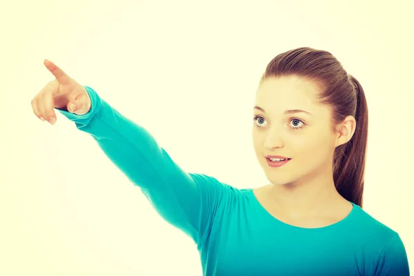 Leende ung kvinna pekar uppåt. — Stockfoto