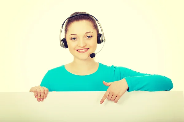 Callcenter-Frau zeigt auf Plakatwand. — Stockfoto