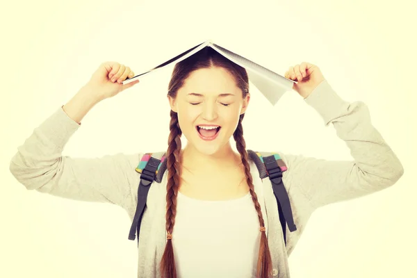 Menina adolescente com livro sobre sua cabeça . — Fotografia de Stock