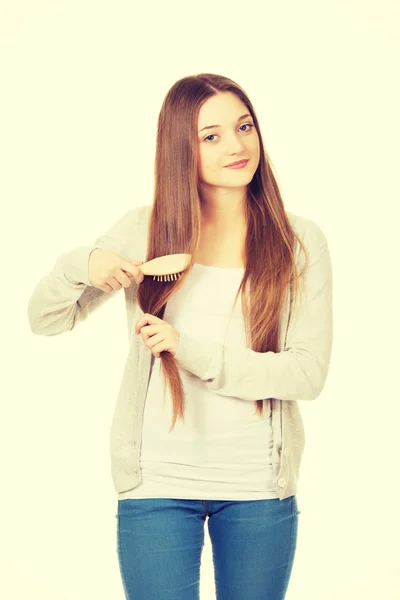 Tiener vrouw haar haren borstelen. — Stockfoto
