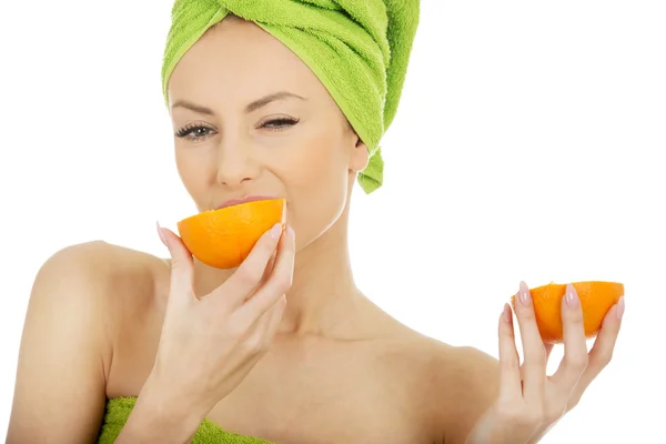 Mooie vrouw eten oranje. — Stockfoto