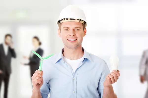 Man with a wind turbine and a light bulb. — Stock Photo, Image