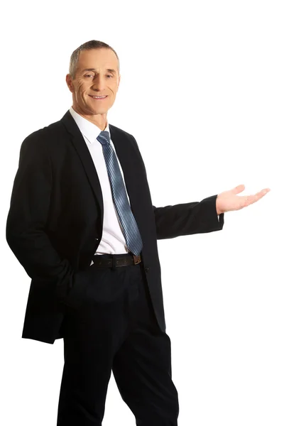 Businessman holding something on his palm — Stock Photo, Image