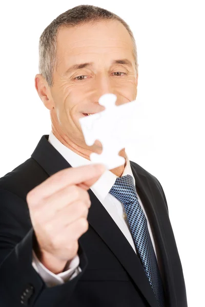 Smart businessman holding a puzzle — Stock Photo, Image