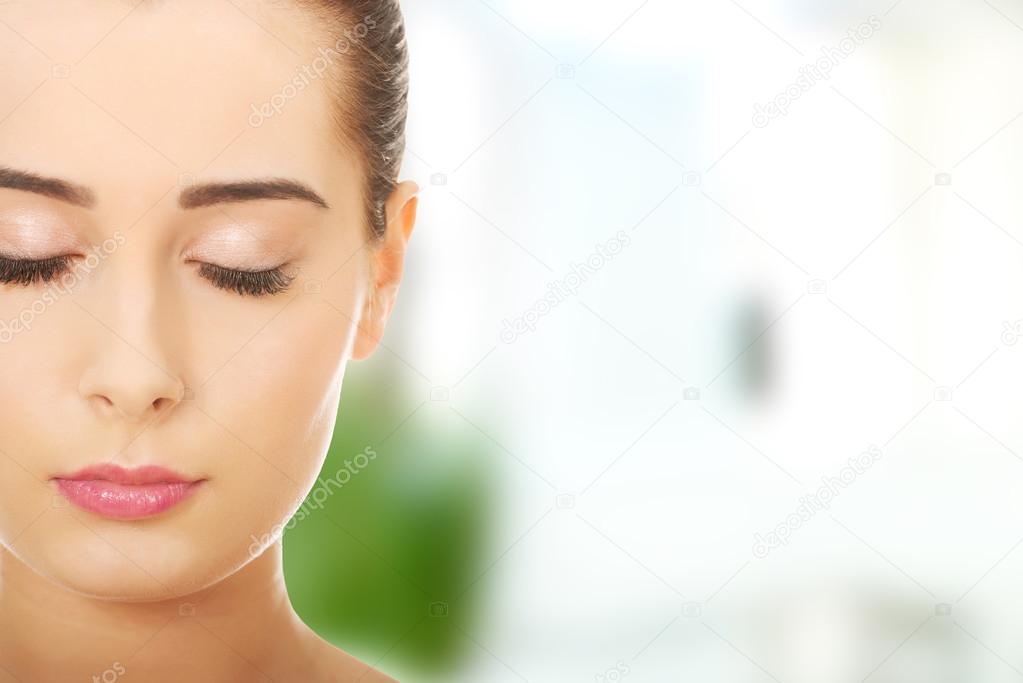 Woman with makeup and eyes closed.