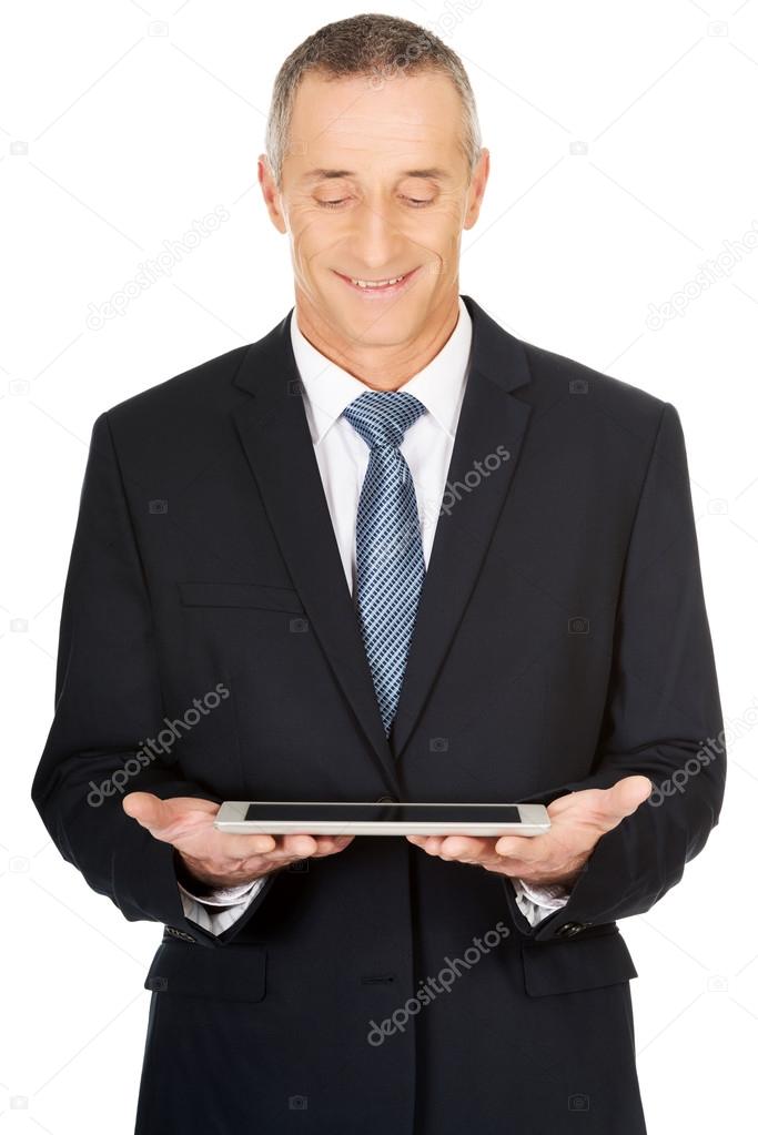 Happy mature man using digital tablet