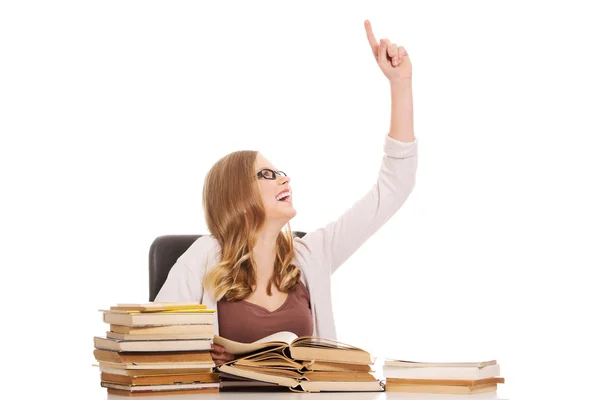 Giovane donna con libri mucchio che punta verso l'alto — Foto Stock