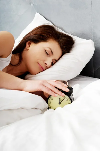 Woman switches off alarm clock. — Stock Photo, Image