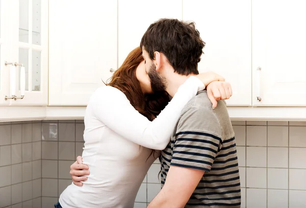 Романтическая пара целуется на кухне . — стоковое фото