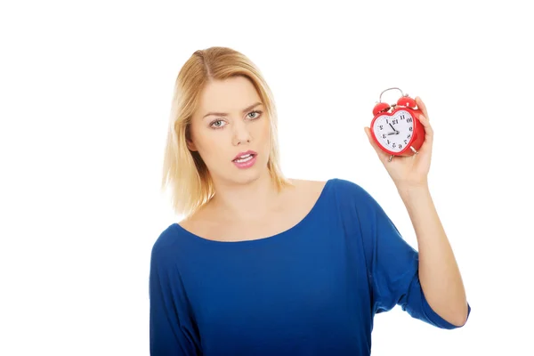 Shocked woman holding a clock. — Stock Photo, Image