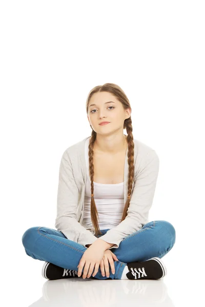 Happy teen woman sitting cross legged. — Stock Photo, Image