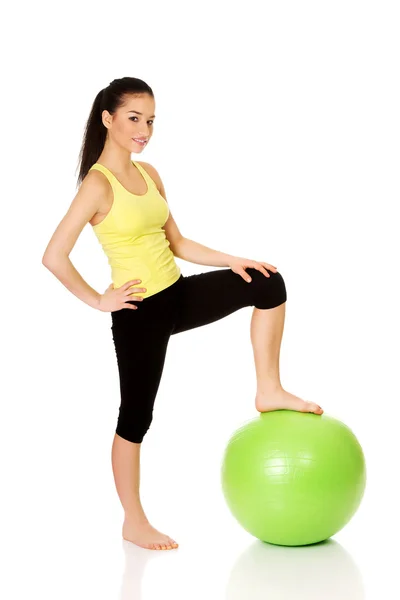 Junge Frau trainiert mit Pilates-Ball. — Stockfoto