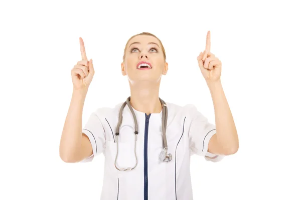 Médico médico mujer apuntando hacia arriba . — Foto de Stock