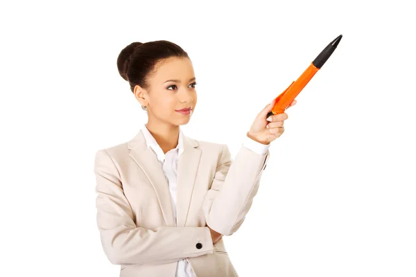 Businesswoman pointing up with big pen. — Stock Photo, Image