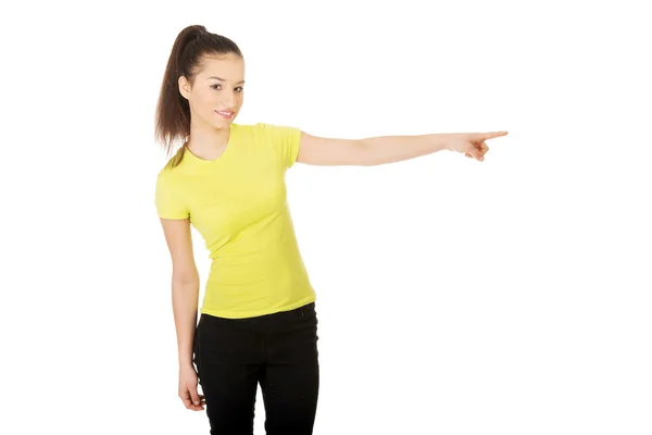 Ung kvinna pekar åt sidan. — Stockfoto