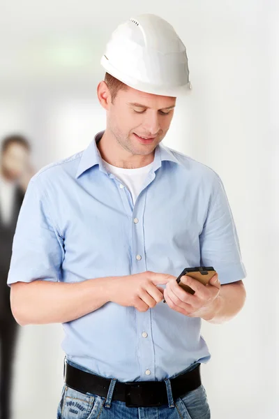 Contratante de chapéu duro usando seu telefone celular — Fotografia de Stock