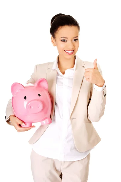 Businesswoman with piggybank and thumbs up. — Stock Photo, Image