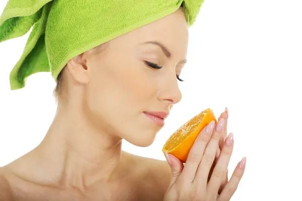 Όμορφη γυναίκα μυρίζει πορτοκάλι. — Φωτογραφία Αρχείου