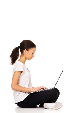 çapraz bacaklı laptop ile oturan genç.