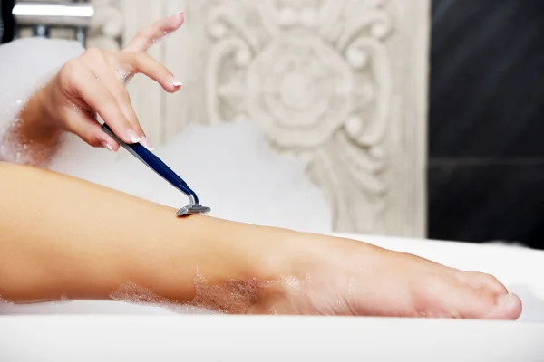 Woman shaving her leg. — Stock Photo, Image