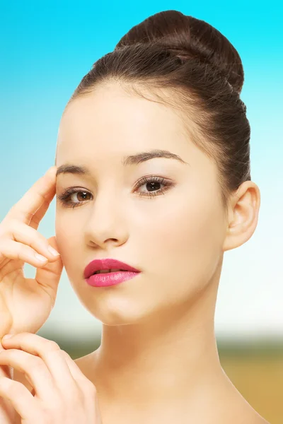 Mujer con maquillaje completo tocando la cara . —  Fotos de Stock